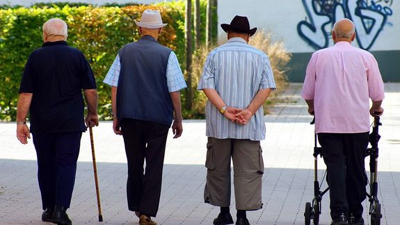 Vier Rentner gehen spazieren. Ansicht von hinten