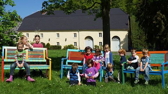 Kindergartenkinder sitzen im Garten 
