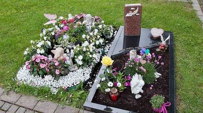 Kindergrab mit Grabstein und Blumen