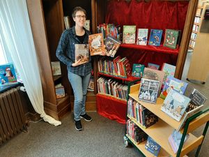Büchereimitarbeiterin Svenja Schulte-Dahmen präsentiert den Weihnachtsschrank der Stadtbücherei.