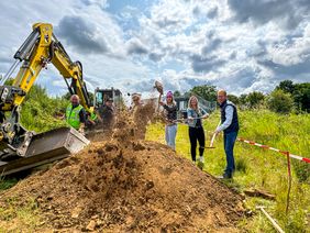 Baggern für den neuen Rollgarten an der Englandstraße: Verwaltungsmitglieder und Mitarbeiter des ausführenden Unternehmens haben sich zum symbolischen Spatenstich getroffen.