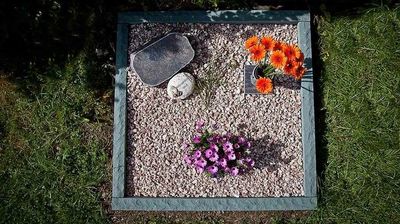 Urnenreihengrab quadratisch mit Kies und Blumen