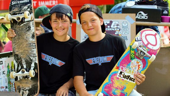 Zwei junge Skateboarder zeigen ihre Boards